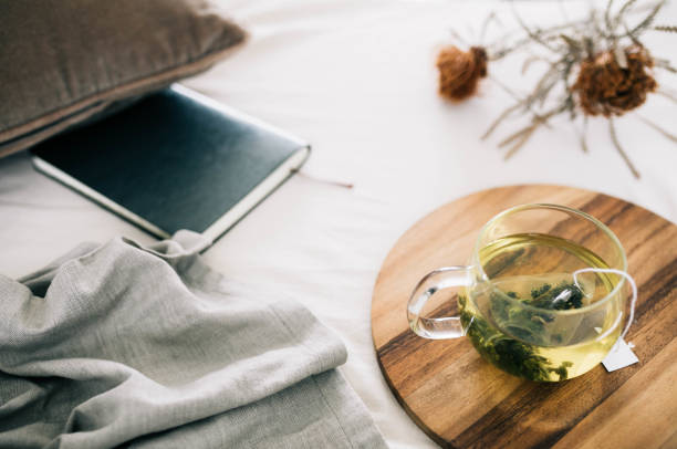 Herbal tea and journal on a bedside table for evening relaxation